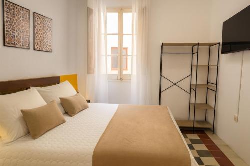 a bedroom with a large white bed with pillows at Casa Antares in Granada