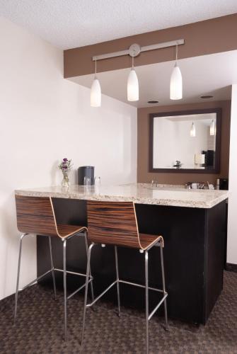 a kitchen with two chairs and a counter with a sink at Hyatt Regency Green Bay in Green Bay
