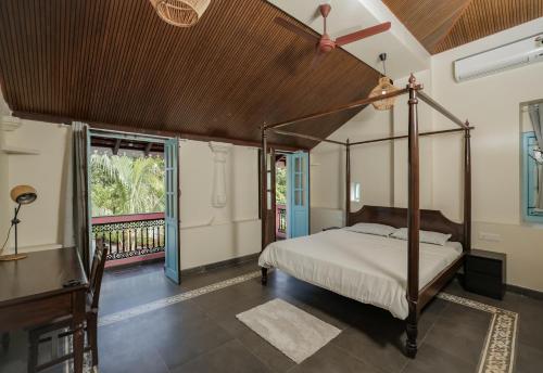 a bedroom with a canopy bed and a balcony at The Village Casa in Aldona