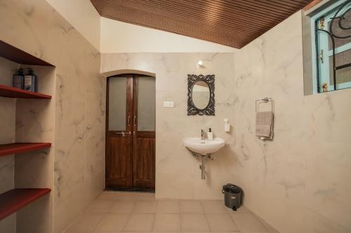 a bathroom with a sink and a mirror on the wall at The Village Casa in Aldona