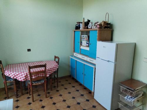 una cucina con un tavolo e un frigorifero bianco di Studio chez Claudine a Conches-en-Ouche