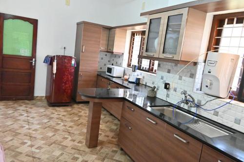 a kitchen with a sink and a refrigerator at Willy's Home Stay in Parūr