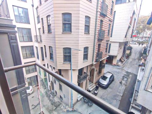 伊斯坦布尔Taksim Luxury Arcadia Hotel的从带汽车的建筑的阳台上可欣赏到风景