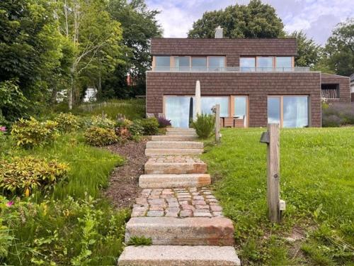 a brick house with a stone path leading to it at Riverside Architect-Designed Garden Apartment in Süderstapel
