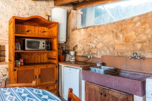 a small kitchen with a sink and a microwave at Can Gallot De Punxuat - Pool in Algaida