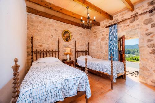 a bedroom with two beds and a window at Can Gallot De Punxuat - Pool in Algaida