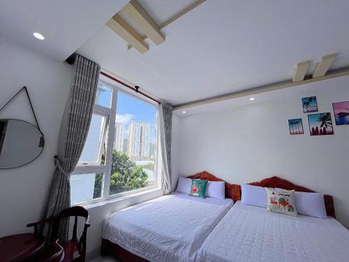 a bedroom with a bed and a large window at New Star Hotel Vũng Tàu in Vung Tau