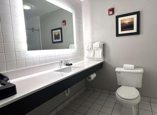 a bathroom with a sink and a toilet and a mirror at Best Western Erie Inn & Suites in Erie