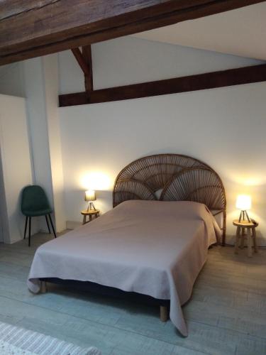 a bedroom with a large bed with two lamps at Les Trois Geais in Les Épesses