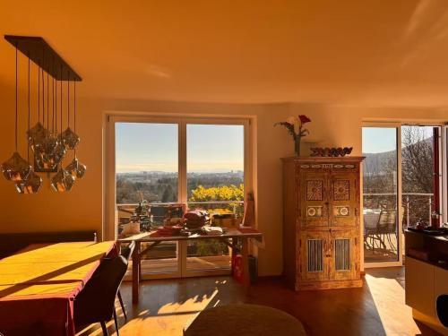 a living room with a table and a large window at Traumhaus mit herrlichem Blick über Graz in Sankt Veit am Vogau