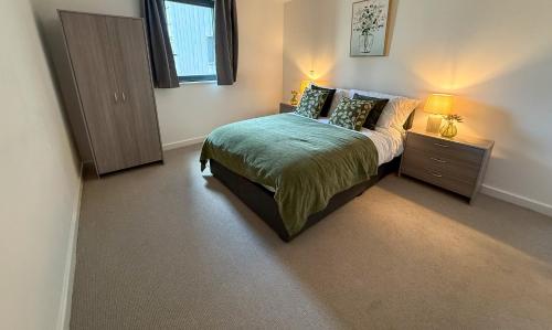 a bedroom with a bed and a dresser and a window at Spacious City Centre 2 Bedroom Apartment in Liverpool