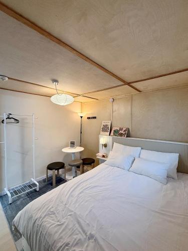a bedroom with a large white bed and a table at Forest SB02 in Seoul