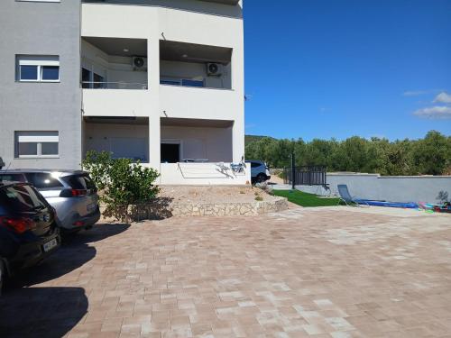 a parking lot in front of a white building at Galešnjak in Sveti Petar