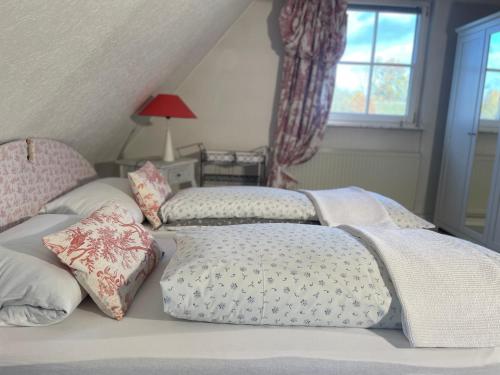 a bedroom with two beds with pillows and a window at Ferienidyll Aumühle, "Wiesengrund" in Rot am See