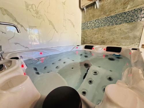 a person sitting in a tub in a bathroom at Chambre maison Normandy in Lieurey
