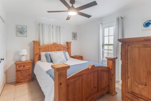 une chambre avec un lit en bois et un ventilateur de plafond dans l'établissement Waterfront Home with Pool by Next Step Property Management, à Pass Christian