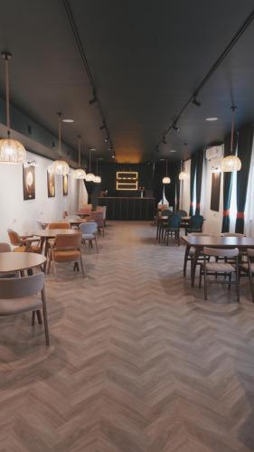 Un comedor con mesas, sillas y luces. en Karibi Complex, en Kyzylorda