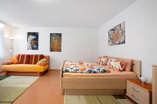 a bedroom with a bed and a couch at Ferienwohnung Grünfelder in Au
