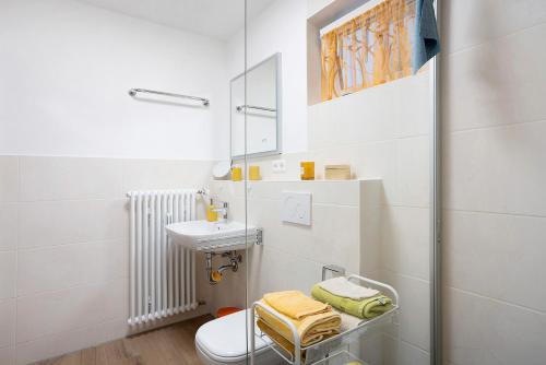 a white bathroom with a sink and a toilet at Ferienwohnung Grünfelder in Au