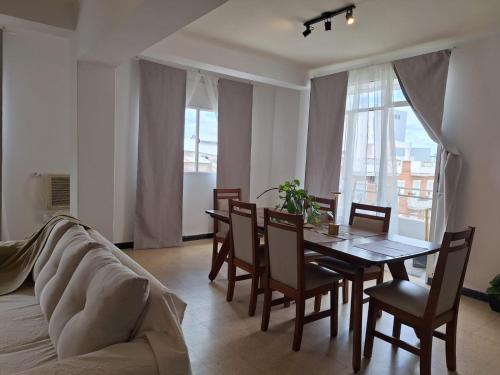 a dining room with a table and chairs and a couch at Microcentro - 4 Personas - 2 dormitorios - Cochera in Santiago del Estero