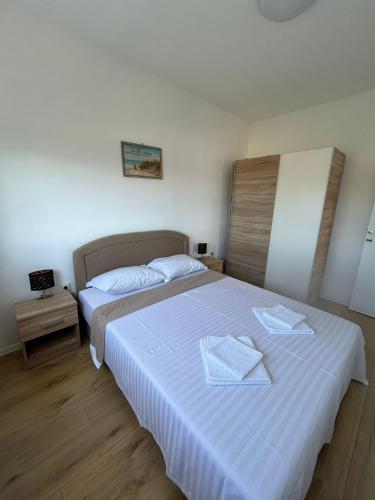 a bedroom with two beds with white sheets at Galešnjak in Sveti Petar