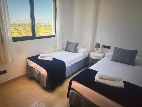 a hotel room with two beds and a window at Large terrace and views in Retamar