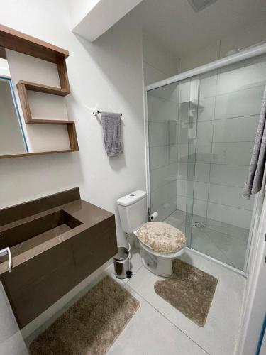 a bathroom with a toilet and a glass shower at Loft moderno e completo a 200m do Consulado Americano in Porto Alegre
