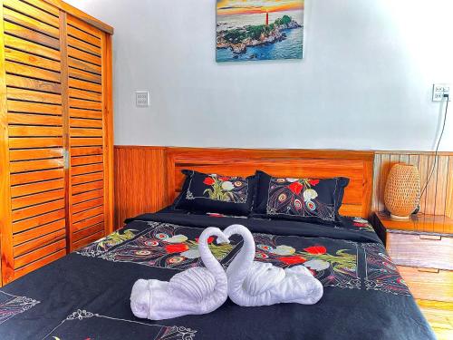 Deux cygnes sont assis au-dessus d'un lit dans l'établissement Homestay Gio bien, à Ấp Ngọc Hải