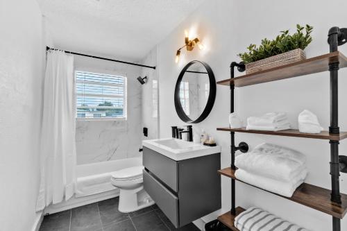 a bathroom with a sink and a toilet and a mirror at Cozy Hollywood Private Pool Retreat - Ping pong in Hollywood