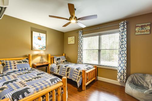 ein Schlafzimmer mit zwei Betten und einem Deckenventilator in der Unterkunft Year-Round Loon Lake Retreat Ski, Hike, Explore! in Chestertown