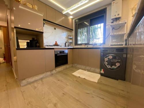 une grande cuisine avec une cuisinière et une fenêtre dans l'établissement Apartement charmante amira, à Oulad Kerroum