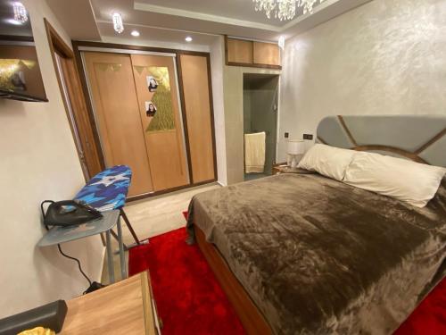 une chambre avec un lit et une chaise dedans dans l'établissement Apartement charmante amira, à Oulad Kerroum