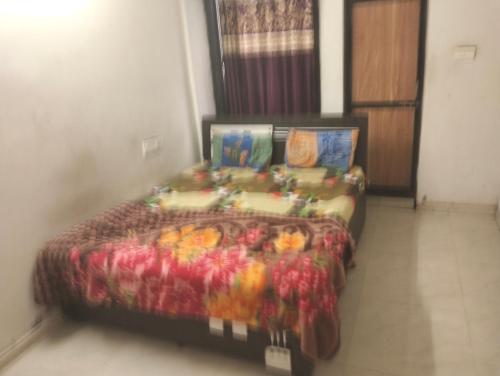 a bed in a room with a colorful bedspread at Gurukrupa Home stay in Rājpīpla