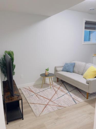 a living room with a couch and a tv at Modern Comfort West Edmonton in Edmonton