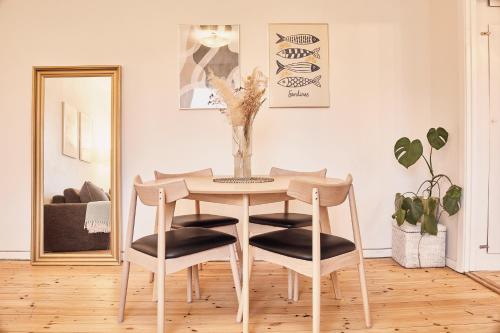 a table and chairs in a room with a mirror at Cozy one bedroom apartment with balcony in Copenhagen