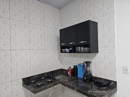 バヘイリーニャスにあるChalé Dunas de Prataのキッチン(黒いキャビネット、カウンタートップ付)