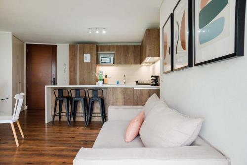 a living room with a couch and a kitchen at Luxury and Comfort in the Heart of Las Condes in Santiago