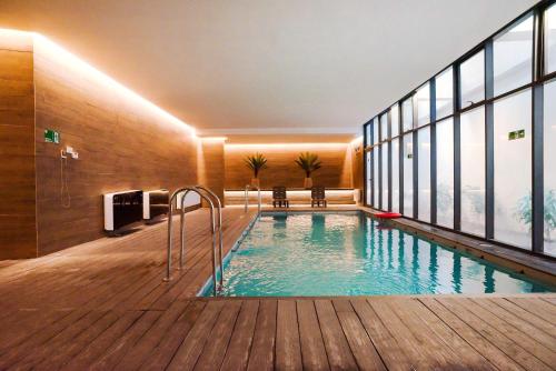 a swimming pool in a hotel room with a large window at Luxury and Comfort in the Heart of Las Condes in Santiago