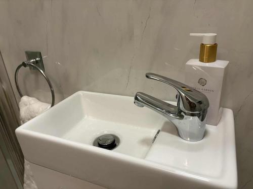 a white sink with a faucet in a bathroom at Cosy Ground-Floor Flat in Omagh Centrally located in Omagh