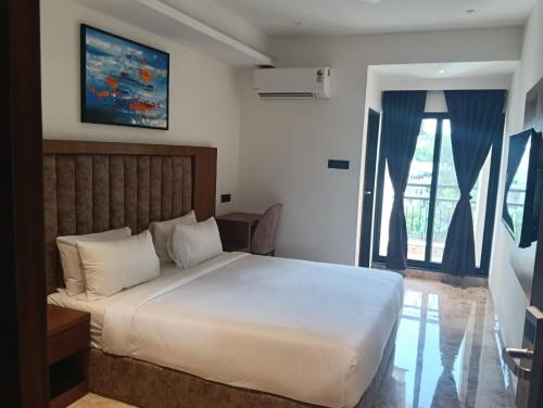 a bedroom with a large white bed and a window at Silvotel Premier By Bizzgrow Hotels in Indore