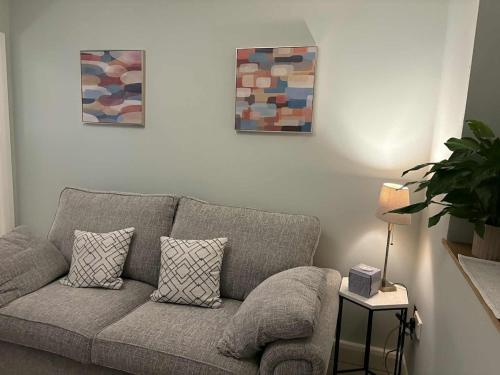 a living room with a couch and two paintings at Cosy Ground-Floor Flat in Omagh Centrally located in Omagh