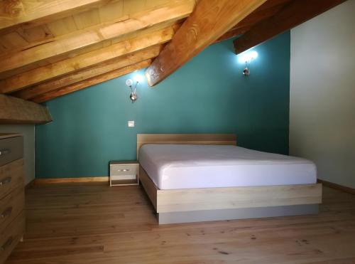 Un dormitorio con una cama y una pared azul. en Gite De Caractère En Pleine Nature, en Bourg-de-Visa