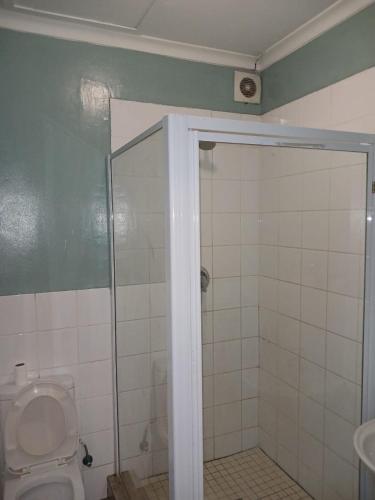 a bathroom with a shower stall and a toilet at Lookout Star Legend Accommodation in Parow