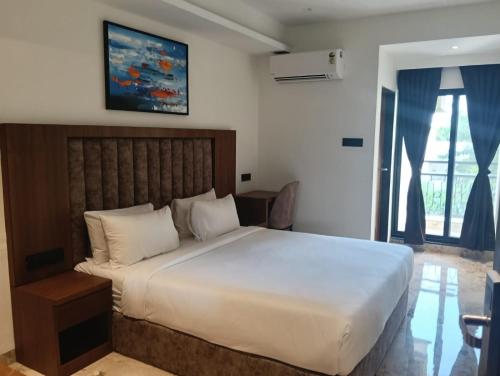 a bedroom with a large white bed in a room at Silvotel Premier By Bizzgrow Hotels in Indore
