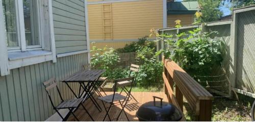 a patio with a table and chairs and a grill at Lovely SELF-SERVICE studio in wooden house, private bath&parking in Turku