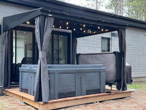 einen Pavillon mit Grill vor einem Haus in der Unterkunft Brand New with SPA - Le Repaire du Lievre Blanc in Saint-Alexis-des-Monts