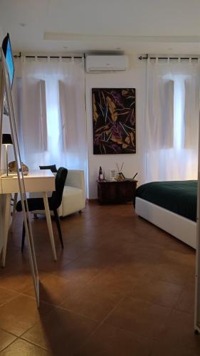 a bedroom with a bed and a desk and a bed and a table at Bilocale in Palazzo del XVI Secolo in Campobasso