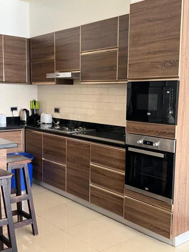 a kitchen with wooden cabinets and a stove top oven at The Happy Nest in Kampala