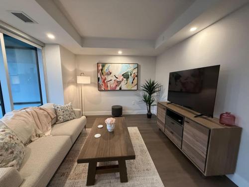 a living room with a couch and a flat screen tv at Spotless vibrant & modern 1 BR with 6 appliances in Halifax