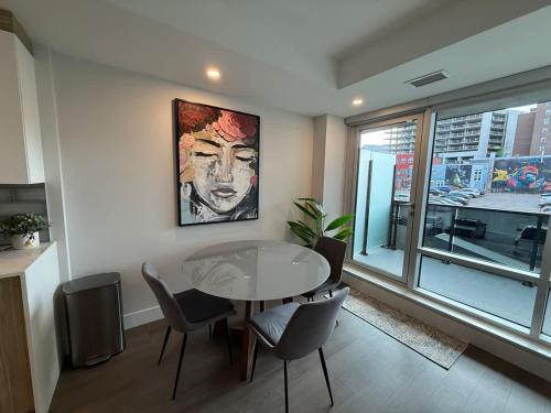 a dining room with a table and chairs and a window at Spotless vibrant & modern 1 BR with 6 appliances in Halifax